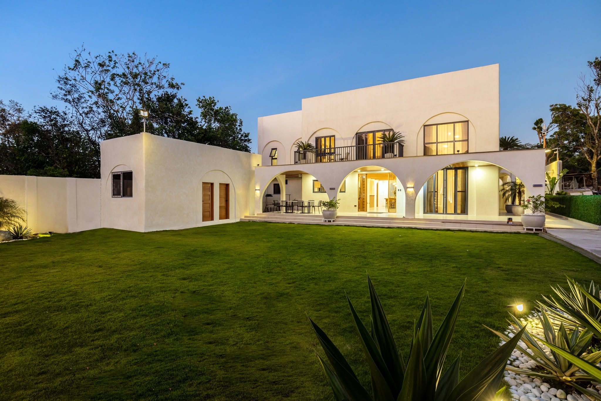 Villa Agave's arched two-story facade glowing at dusk